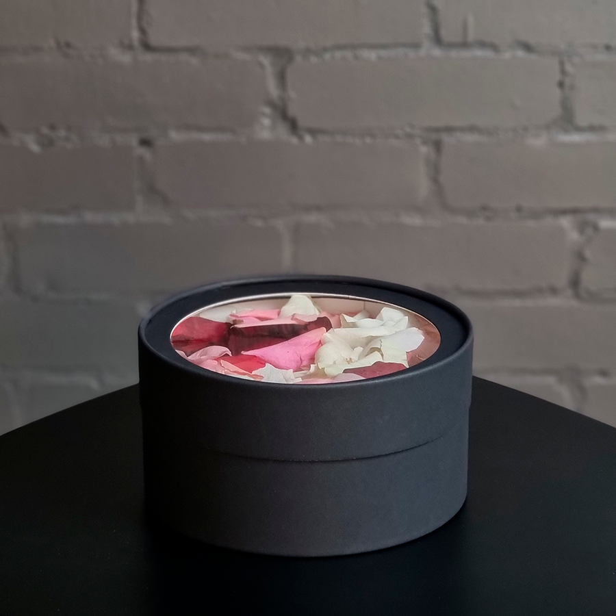 Лепестки роз в круглой коробке, черного цвета.