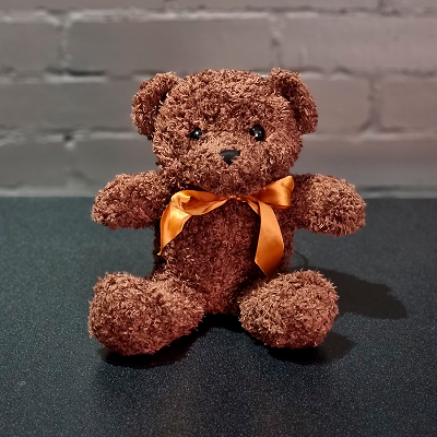 Плюшевый мишка, бурый, с бантом.